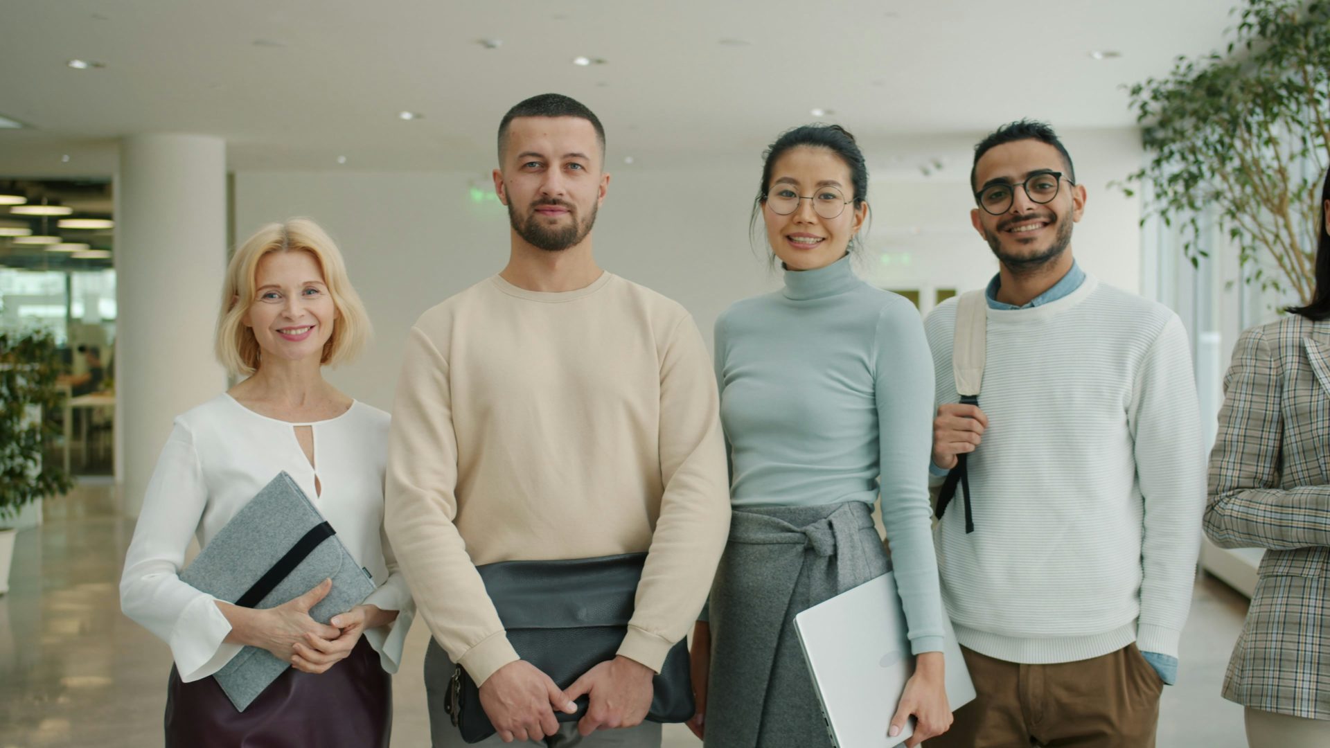 Un grupo diverso de profesionales de pie juntos en interiores.